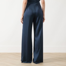 Model wearing Marella aviation blue wide-leg satin trousers, rear view showing high waist and fluid drape