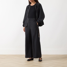 Model wearing Max&Co Moli Technical Blouse in black with wide-leg trousers and black ballet flats
