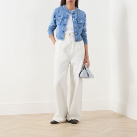 Model wearing Max&Co Staffa Deep Blue stone-washed cardigan with white wide-leg trousers, styled with a grey mini bag and black flats.