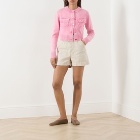 Model wearing Max&Co Staffa Stone-Washed Cardigan in pink with snap buttons and chest pockets, styled with cream shorts and taupe flats.