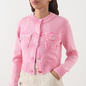 Model wearing Max&Co Staffa Stone-Washed Cardigan in pink with round neck, snap buttons, chest pockets, and ribbed trims, styled with cream trousers