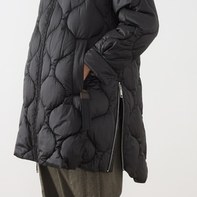 Model wearing Max&Co Vello Quilted Coat in black, showing onion quilting detail and side zip slit, styled with khaki trousers