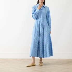 Model wearing Max&Co Ritmo Stripe Shirt Dress in light blue with pointed collar, cinched waist and flared midi skirt, styled with cream mules