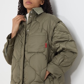 Model wearing khaki quilted oversized jacket with chest patch pocket and red label tab detail