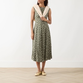 Model wearing Max&Co Virgola Floral Dress in Kaki Print, midi length with flared skirt, styled with a cream shawl and yellow flat shoes.