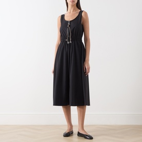 Model wearing Max&Co black sleeveless midi dress with scoop neck, drawstring waist detail, and flared skirt, styled with black flat shoes.