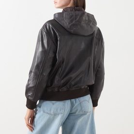Model wearing Max&Co dark brown leather hooded bomber jacket with ribbed cuffs and hem, styled with light blue jeans. Back view.