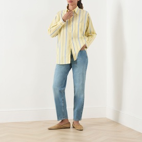 Model wearing Max&Co Dama Stripe Shirt in yellow with blue stripes, styled with light blue straight-leg jeans and tan loafers.