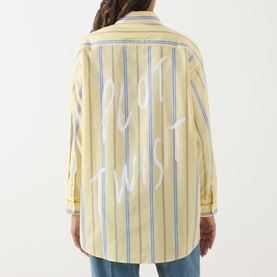 Model wearing Max&Co Dama Stripe Shirt in yellow, rear view showing "Plot Twist" slogan graphic on striped cotton back