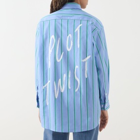 Model wearing Max&Co Dama Stripe Shirt in light blue with green stripes and "Plot Twist" slogan graphic to the back