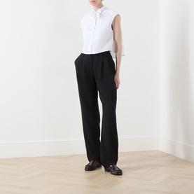 Model wearing Max&Co Optical White sleeveless cotton shirt with black wide-leg trousers and dark loafers