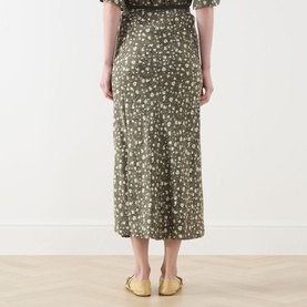 Model wearing Max&Co Agenda Printed Skirt in Kaki Print, midi length with floral jacquard design, styled with yellow flat mules.