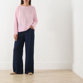 Model wearing Max&Co Stampa Knit Sweater in pink plain with navy wide-leg trousers and beige flat shoes.