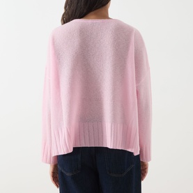 Model wearing Max&Co Stampa Knit Sweater in pink, showing rear view with ribbed trims, dropped shoulders, and split side seams. Styled with dark
