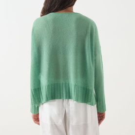 Model wearing Max&Co Stampa Knit Sweater in Green Plain, rear view, showing dropped shoulders, ribbed hem and split side seams, styled with white