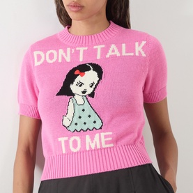 Model wearing Max&Co Argento Graphic Knit Top in pink jacquard with intarsia girl graphic and "Don't Talk To Me" slogan, crew neck, short sleeves