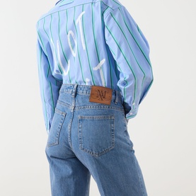 Model wearing Max&Co Liriche Mid-Rise Wide Leg Jeans in navy with leather logo label, styled with a blue striped shirt