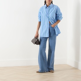 Model wearing Max&Co Liriche Navy Wide Leg Jeans with blue striped shirt, carrying a small brown bag, styled with grey loafers