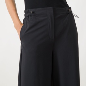 Model wearing Max&Co Orche Technical Straight Leg Trousers in black, showing elasticated drawstring waistband and wide-leg cut with side pockets.