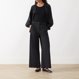 Model wearing Max&Co Orche Technical Straight Leg Trousers in black, styled with a black top, zip jacket and flat shoes.