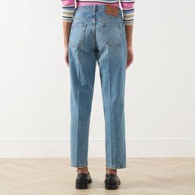Model wearing Max&Co navy denim trousers, rear view, styled with a striped top and black loafers. Straight-leg, high-rise fit.
