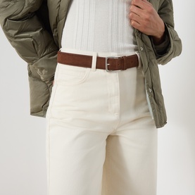 Model wearing Max&Co milk white cotton trousers with brown leather belt, styled with olive quilted jacket and white ribbed top.