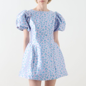 Model wearing Sister Jane Wisteria Jacquard Mini Dress in blue floral jacquard with puff sleeves and voluminous flared skirt.