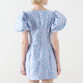 Model wearing Sister Jane Wisteria Jacquard Mini Dress in floral blue, showing rear view with puff sleeves, zip back and voluminous flared skirt.