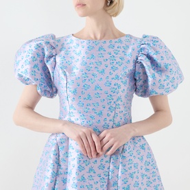 Model wearing Sister Jane Wisteria Jacquard Mini Dress in blue floral jacquard with puff sleeves, round neckline, and fitted bodice.