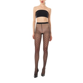 Model wearing Wolford black sheer tights with all-over polka dot pattern, styled with a black bandeau top and heels.