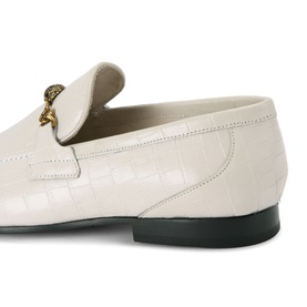 Cream croc-embossed leather loafer with gold lion-head hardware detail and black sole, angled close-up view