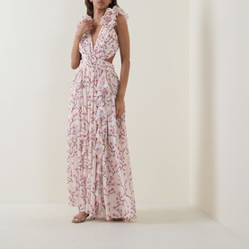 Model wearing Anne Louise Boutique pink floral maxi dress with deep V-neck, ruffle shoulders, cutout waist, and full pleated skirt