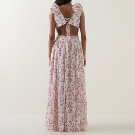Model wearing Anne Louise Boutique pink floral maxi dress with lace-up open back, flutter sleeves, and full skirt.