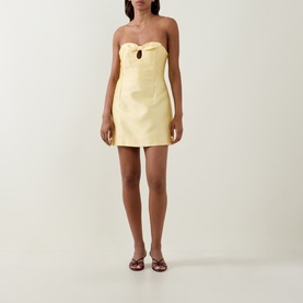 Model wearing Bernadette soft yellow strapless mini dress with sweetheart neckline cutout detail, styled with brown strappy heeled sandals