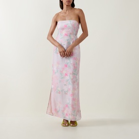 Model wearing Bernadette strapless maxi dress in Clematis Montana Pink floral print with side split, styled with gold strappy heels