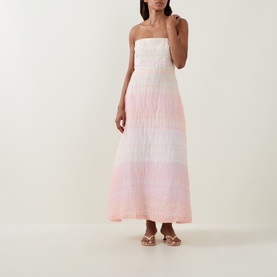 Model wearing Bernadette Dress in Spanish Seaside, ombre pink strapless maxi with smocked bodice, styled with gold flat sandals