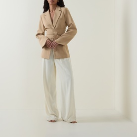Model wearing Odd Muse camel belted blazer with wide-leg cream trousers and tan strappy sandals.