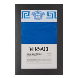 Versace Low Rise Trunk in electric blue, packaged with Greca-patterned waistband and Medusa logo branding visible on box.