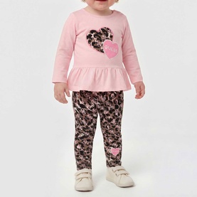 Model wearing Guess Polly Pink 2-piece set; pink frill-hem top with leopard heart print and matching floral leggings with heart detail