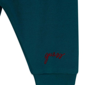 Guess children's Green Tree joggers close-up showing red embroidered script logo on cuffed hem, part of a 3-piece set
