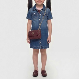 Model carrying Guess deep maroon small crossbody bag with gold chain strap, styled with a denim shirt dress and loafers.