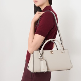 Model carrying cream structured saffiano leather tote bag with gold-tone hardware, twin top handles and detachable shoulder strap, small charm tag