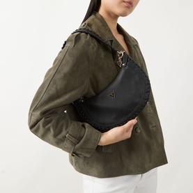 Model carrying Guess Petra Small Braided Hobo Bag in black with gold-tone hardware, braided trim detail and triangular logo badge, styled with olive