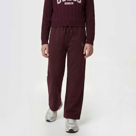 Model wearing dark burgundy wide-leg joggers with drawstring waist, styled with a cable-knit sweatshirt and silver trainers