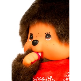 Monchhichi plush toy close-up showing brown fluffy face and red outfit with white snowflake detail, finger in mouth pose