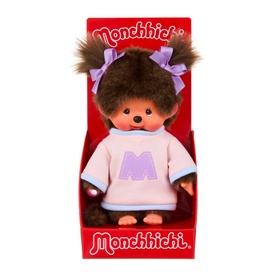 Monchhichi plush doll in pink sweatshirt with purple M logo, brown hair with lilac bows, displayed in red branded box