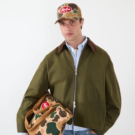 Model with New Era 9FIFTY Camo Baseball Cap in multi, styled with an olive zip jacket and camo tote bag.