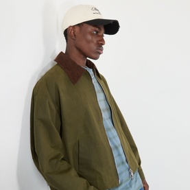 Model with New Era Wash Distress 9TWENTY A-Frame Cap in Cream, curved distressed visor, worn with olive bomber jacket