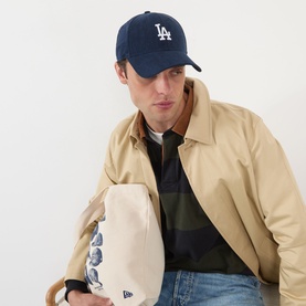 Model with New Era LA Dodgers MLB 9FORTY Baseball Cap in navy, featuring curved visor and embroidered LA logo, styled with beige jacket