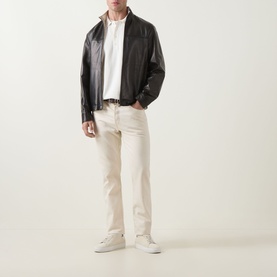 Model wearing Canali black leather casual jacket, styled with white shirt, cream trousers and white trainers